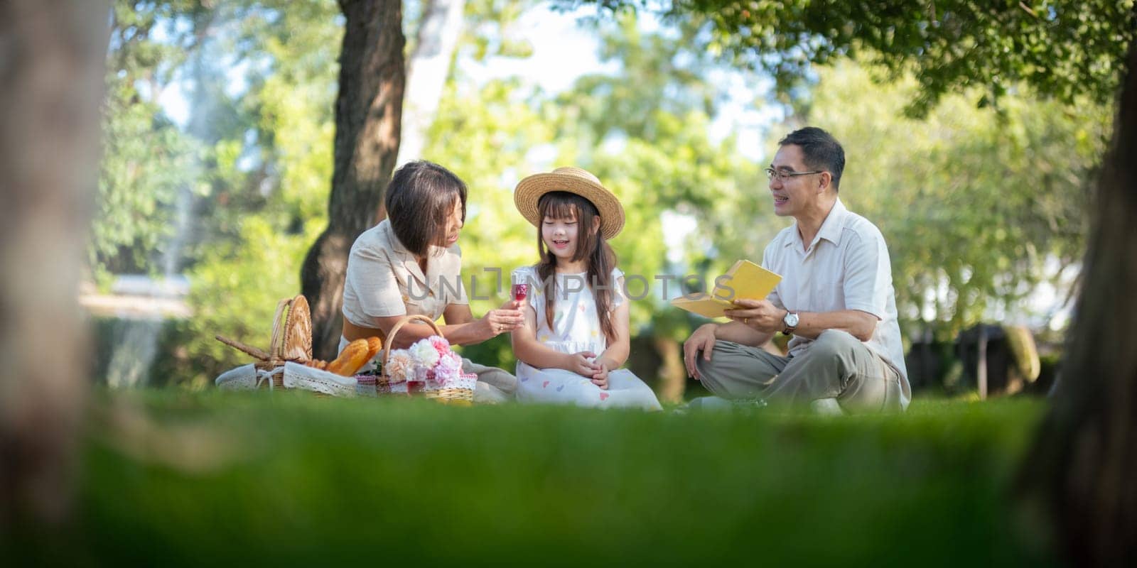 Grandparent playing togetherness with a granddaughter in the park in the morning. Family, love and grandchild bonding with grandfather and grandma in a park. concept child and senior by nateemee