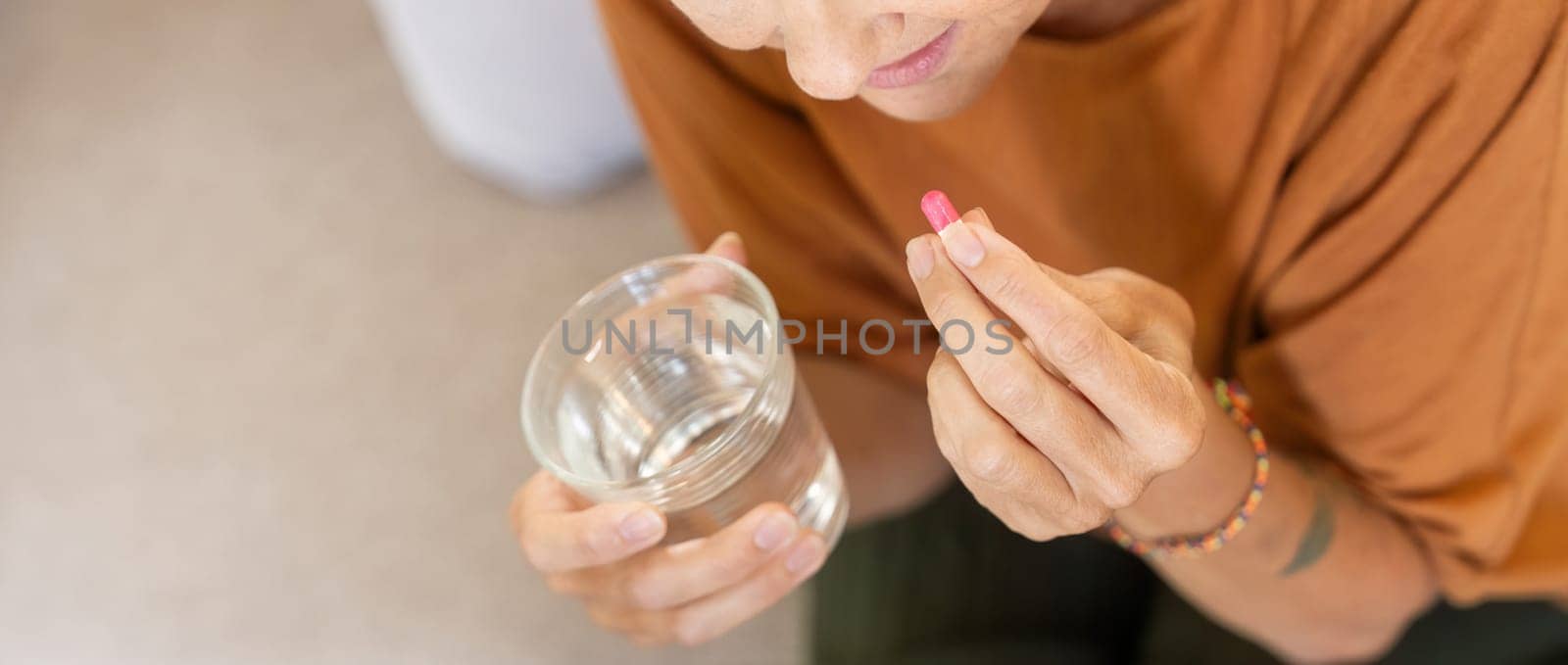 Medicine and healthcare of senior woman taking daily pill for relief illness. vitamin or supplement in his hand.