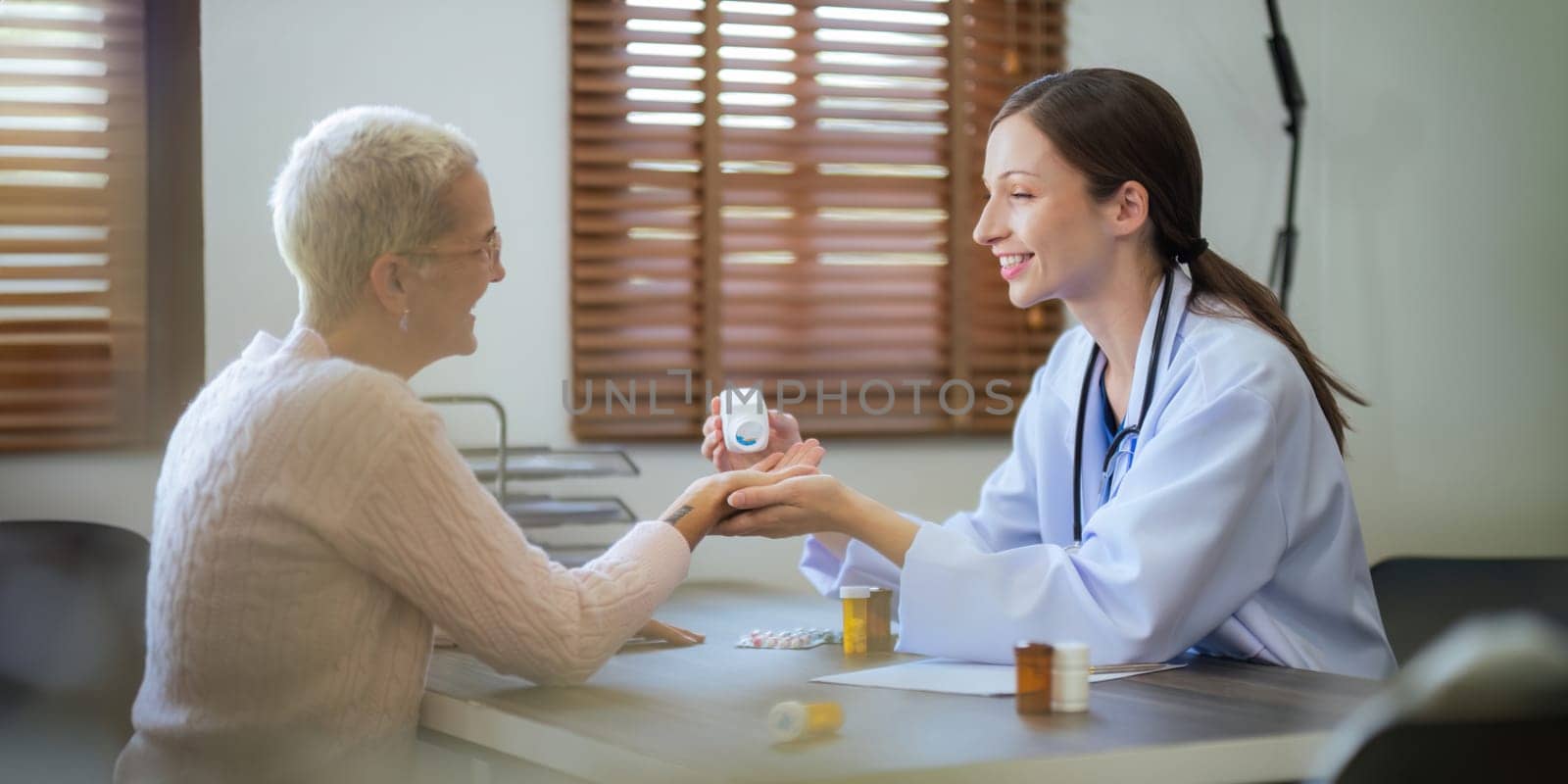 doctor discussion results or symptoms and gives Give advice about medicine to a senior women patient, giving consultation during medical examination in clinic.