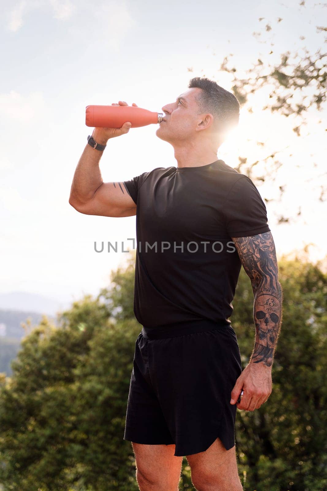 man drinking water during her training, concept of sport in nature and healthy lifestyle