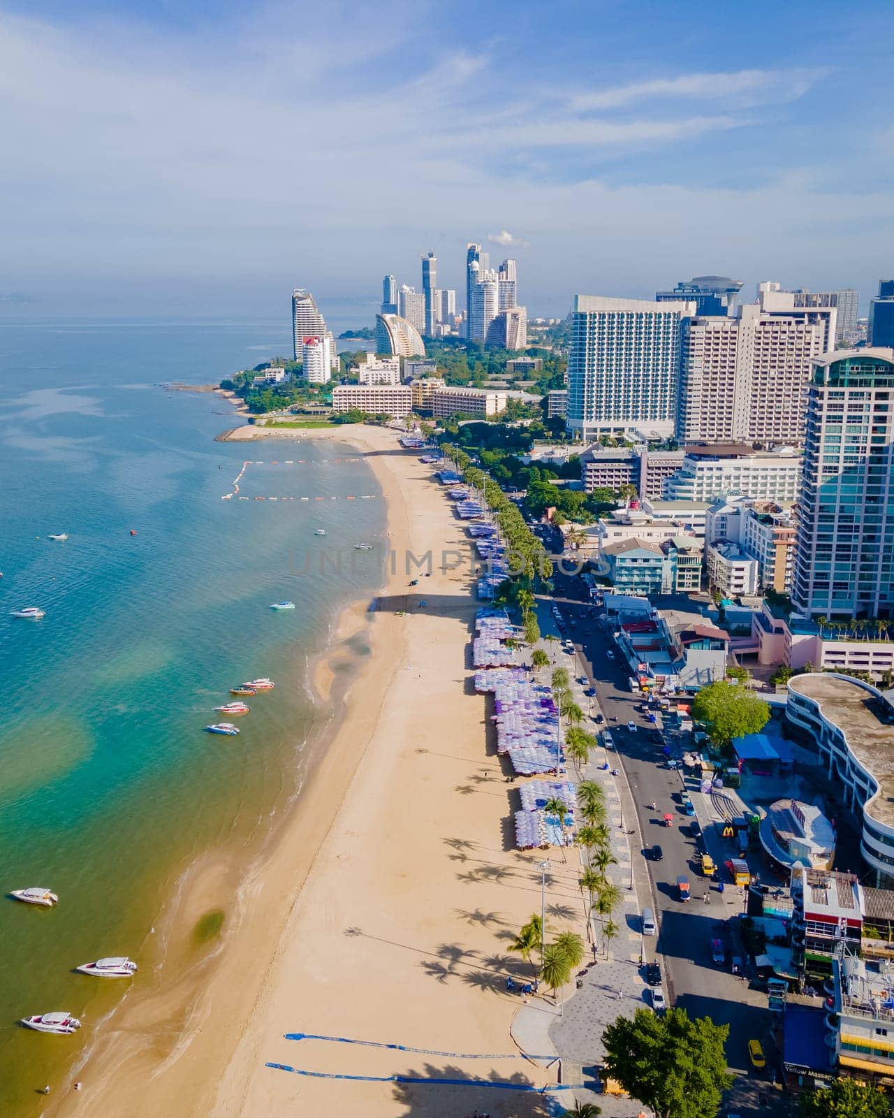 Pattaya Thailand, a view of the beach road with hotels and skyscrapers buildings alongside the renovated new beach road. Drone aerial view of the beach of Pattaya