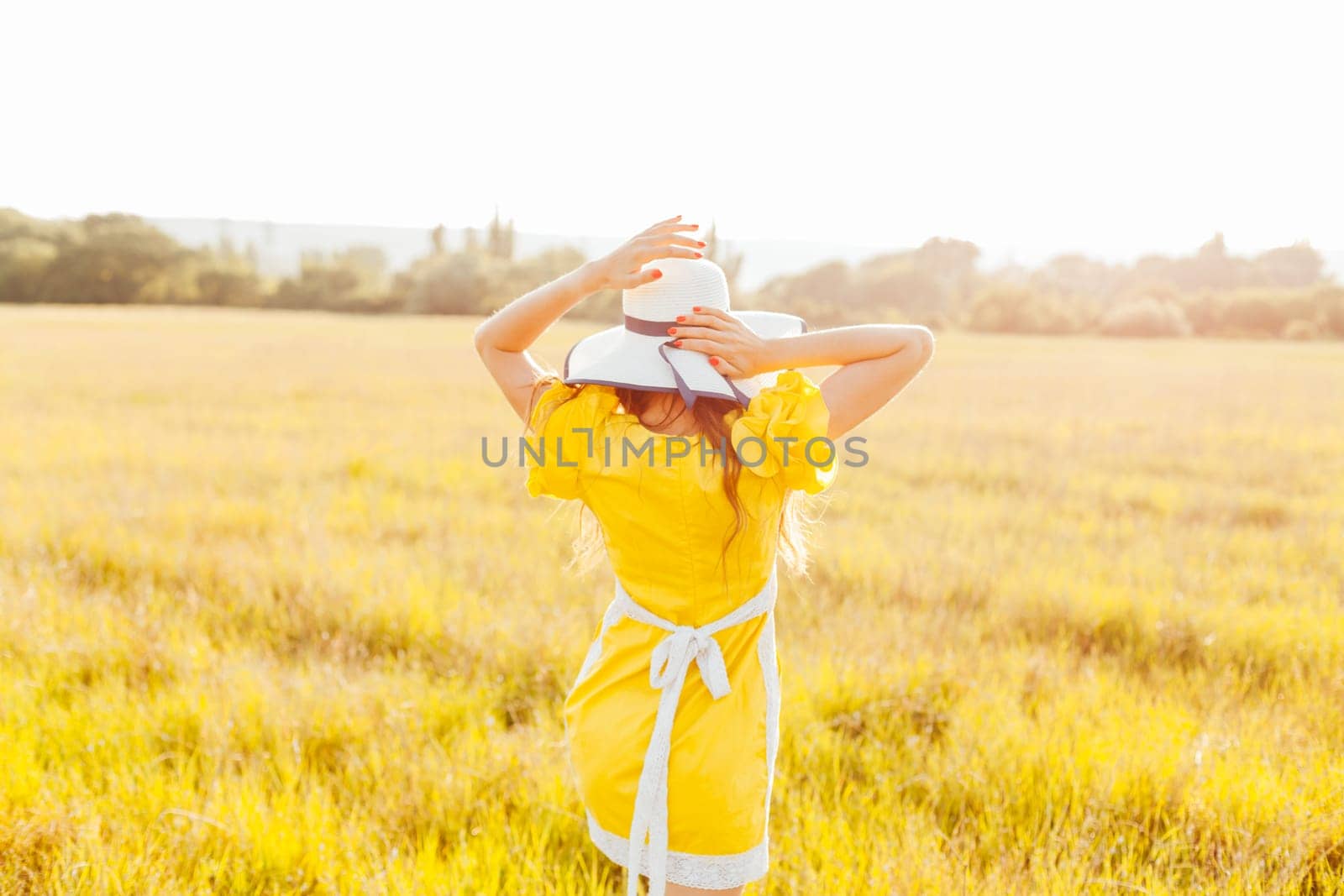 woman in yellow dress and hat in nature holiday walk trip by Simakov