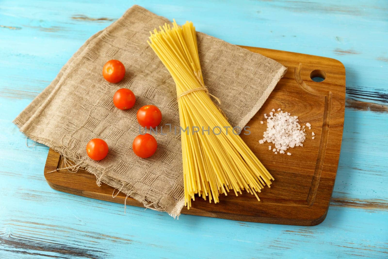 Italian Spaghetti pasta raw food blue background.