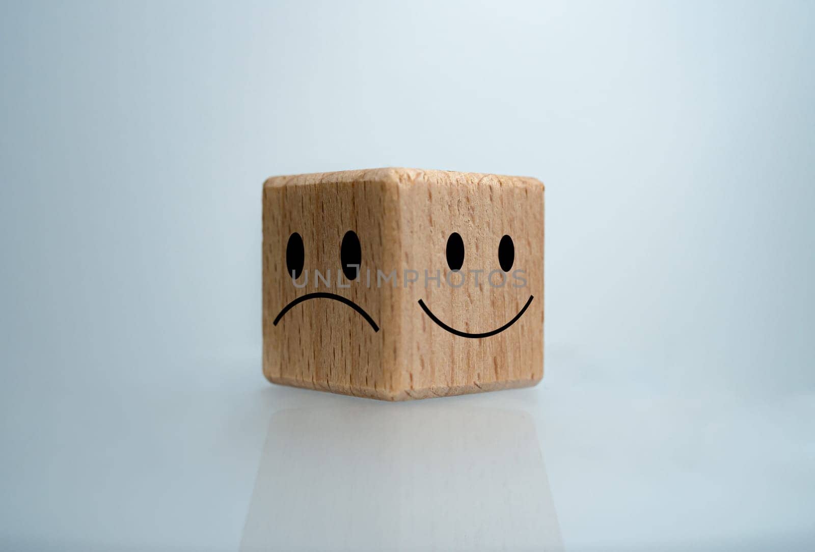 Mental health and emotional state concept, Smile face  and sad face on wooden block cube for positive mindset selection concept. by Unimages2527