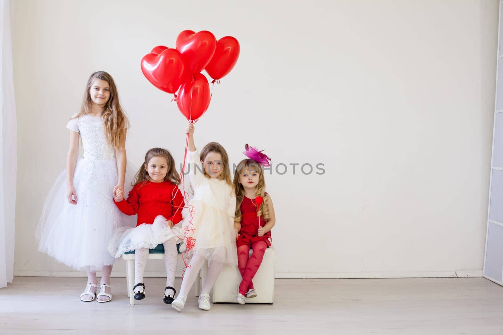 a four children with red balloons in the holiday room