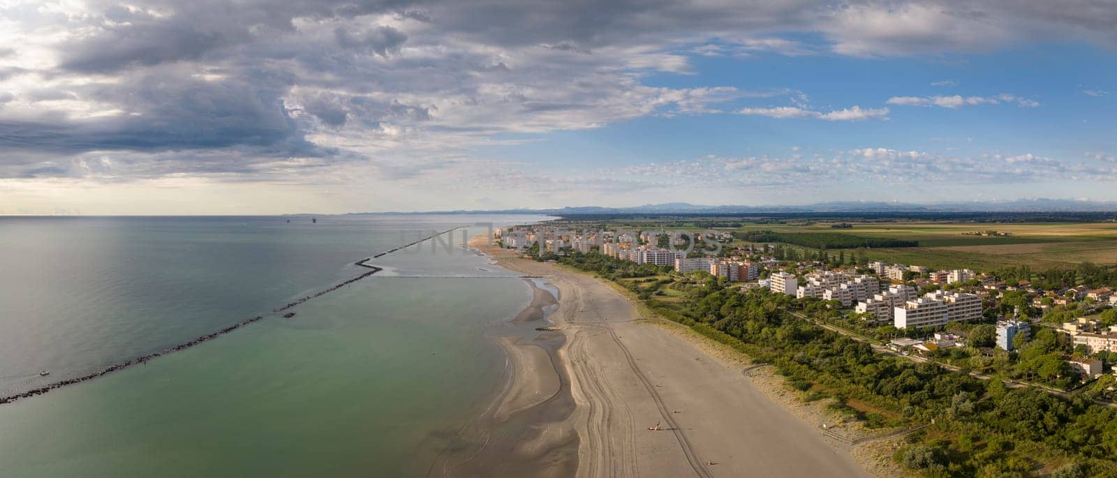 Wonderful aerial shot of sandy beach with parasol and Lido Adriano town by Robertobinetti70