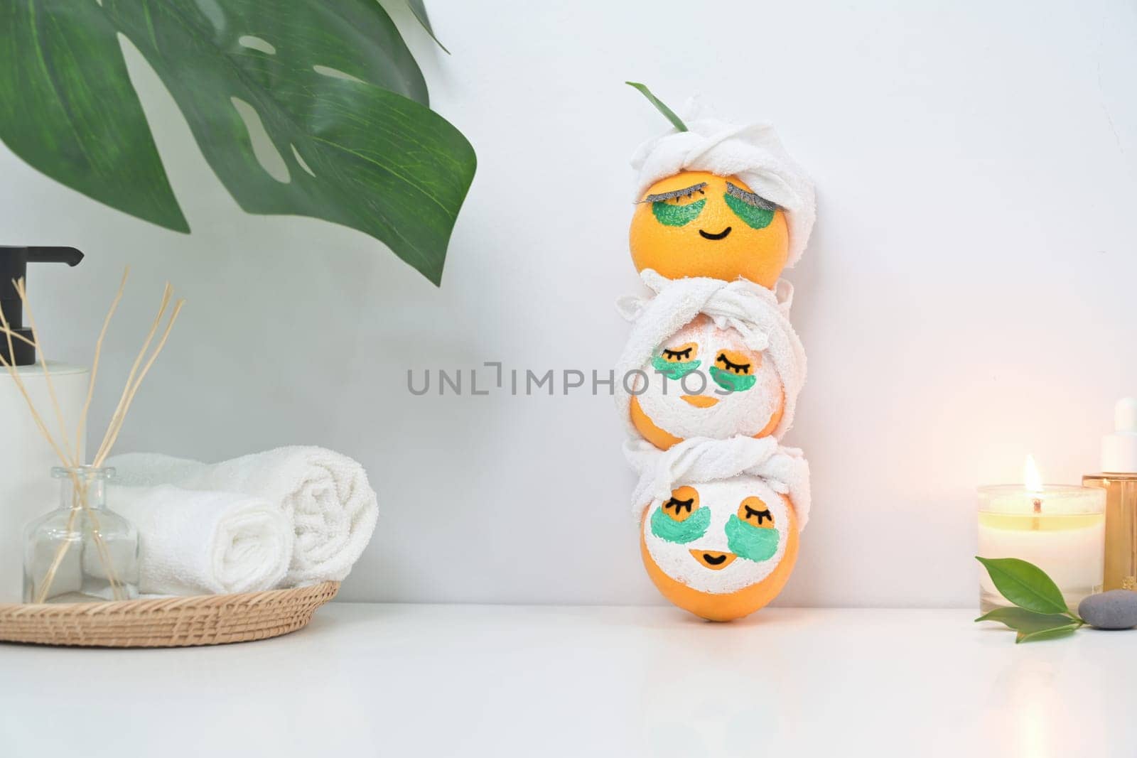 Orange fruits with towel and patches under eyes. Spa treatment and self care concept by prathanchorruangsak