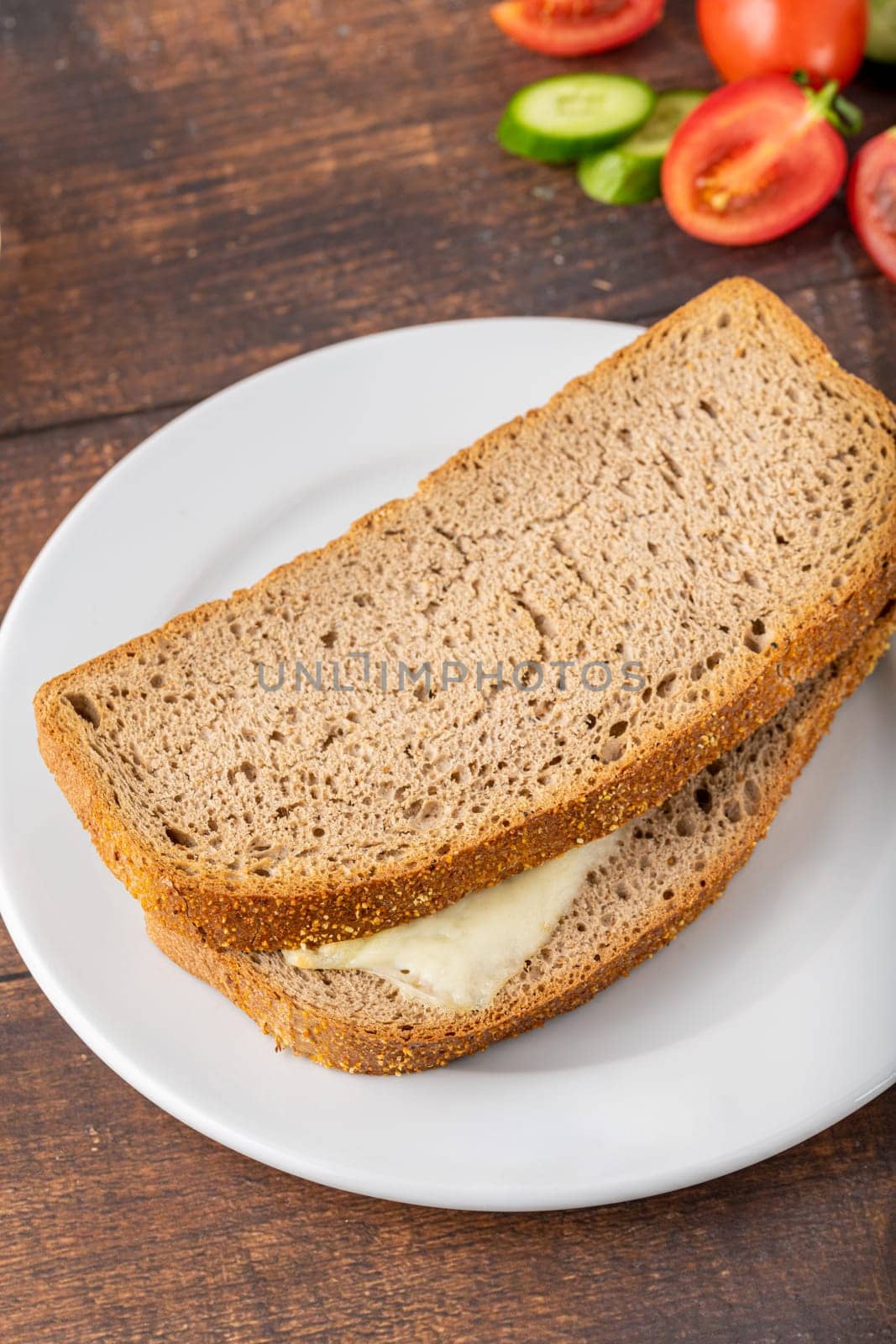 Cheddar toast on white porcelain plate on wooden table by Sonat