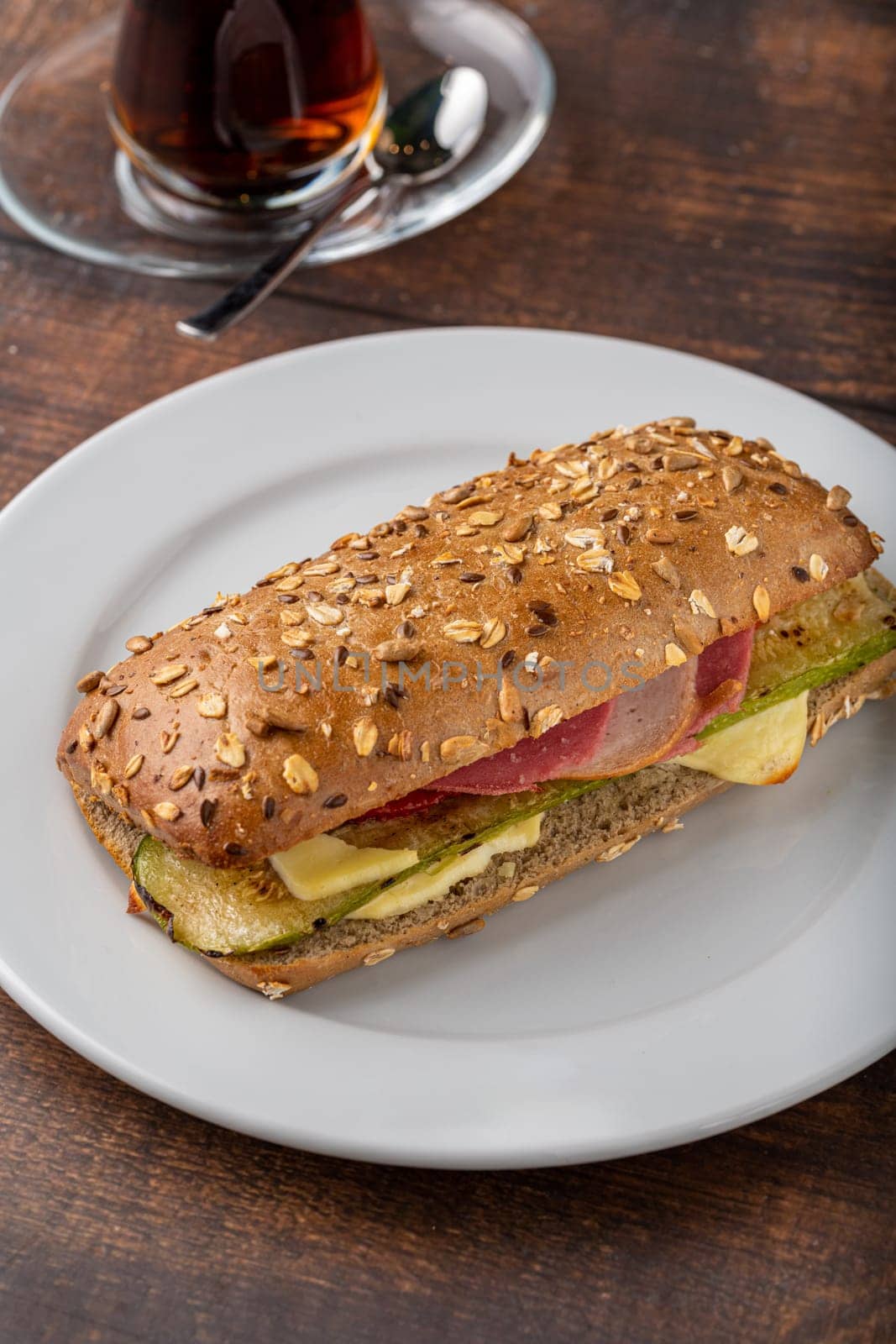 Vegetable and ham sandwich with tea on wooden table