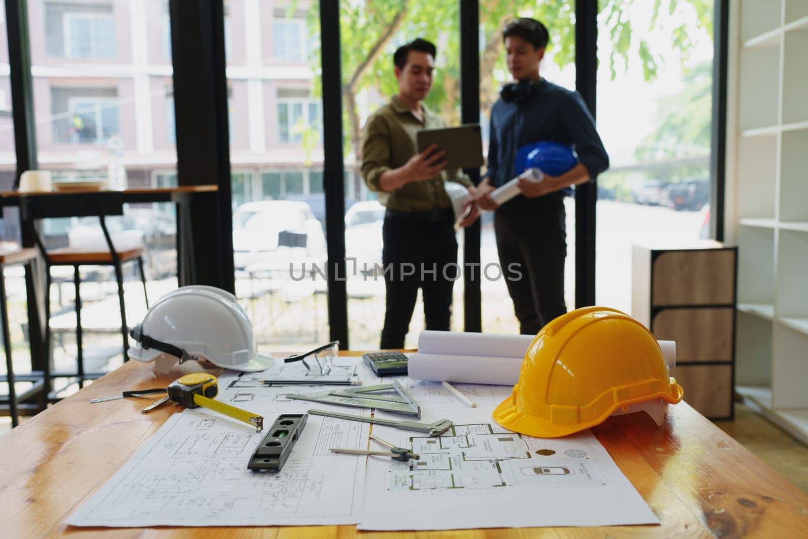engineers discuss building on blueprint drawing, design building Project in office