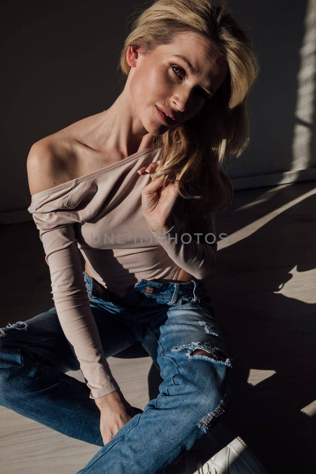 fashion woman blonde sitting in a dark room by Simakov