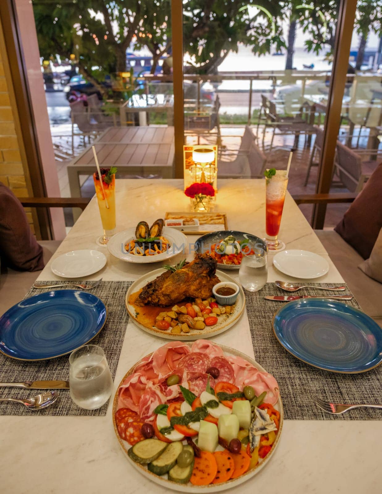 dinner table in an Italian restaurant in Thailand, antipasti with pork and pizza