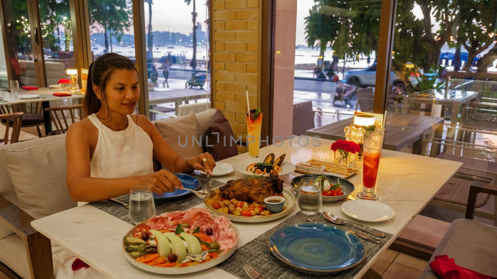 Asian woman having dinner in an Italian restaurant in Thailand