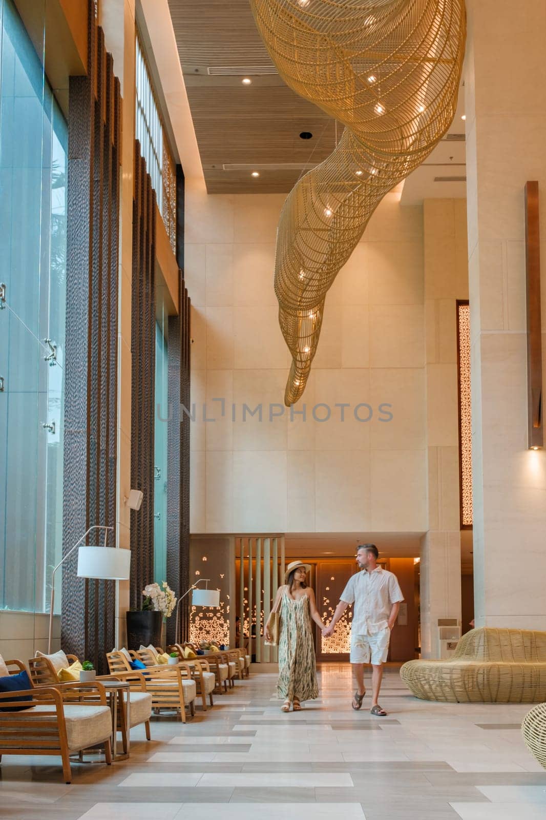 a couple of men and a woman walking in a hotel lobby of a luxury hotel in Thailand