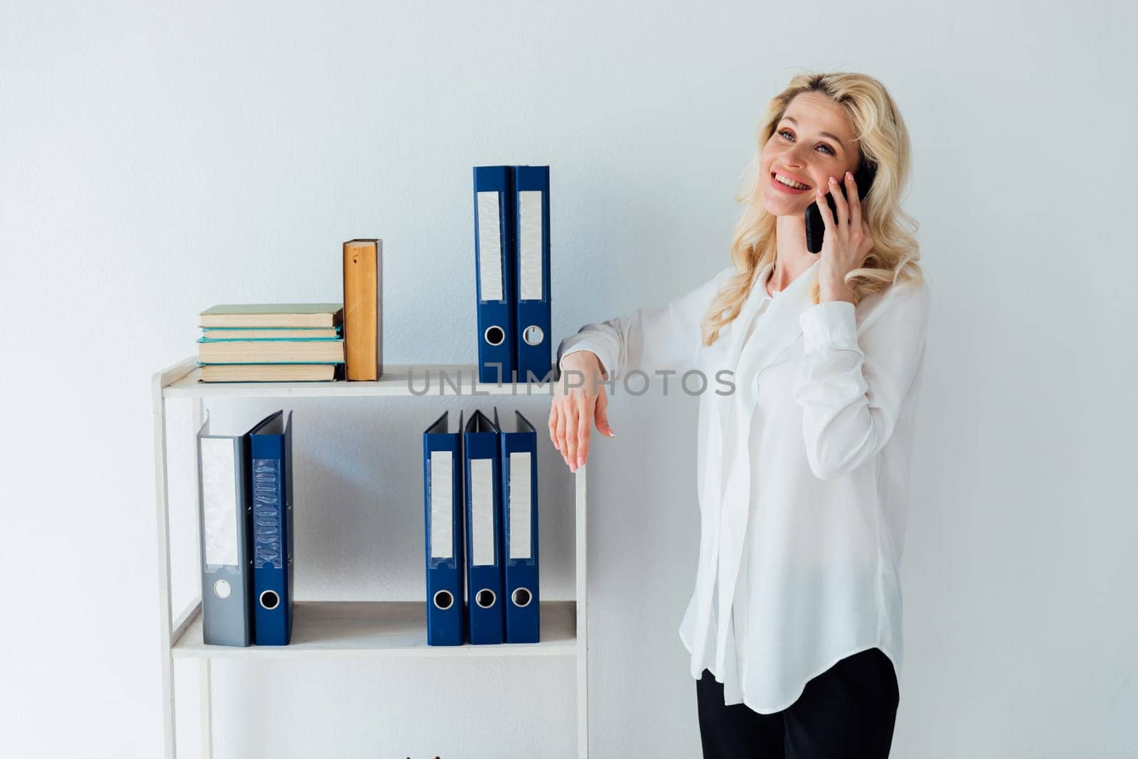woman in office talking on phone business finance work by Simakov
