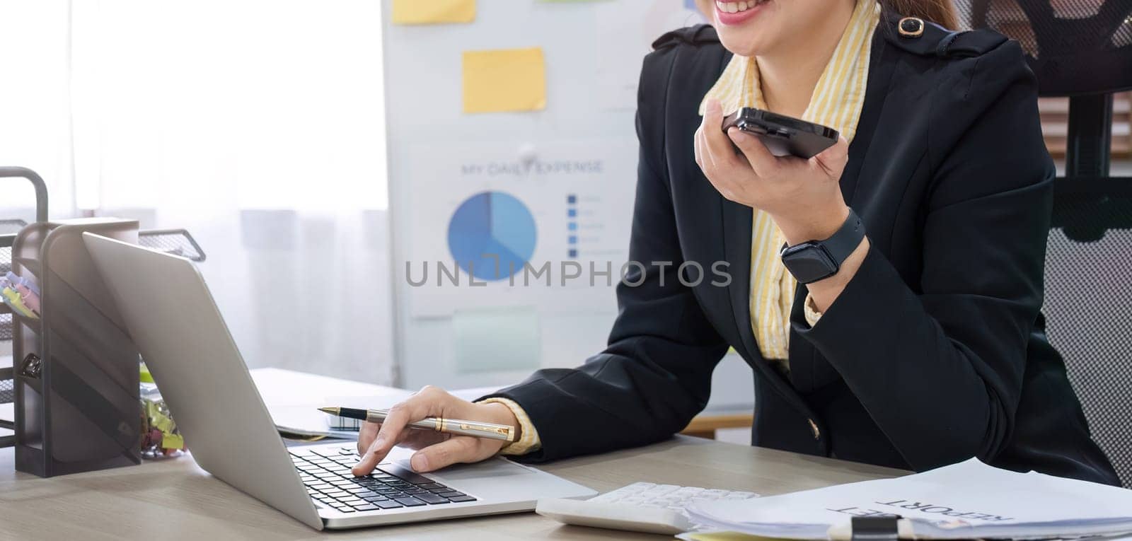 close up, Businesswoman using laptop to do finances, talking on phone, working with numbers on wooden table in office and business background, taxes, accounting, statistics.