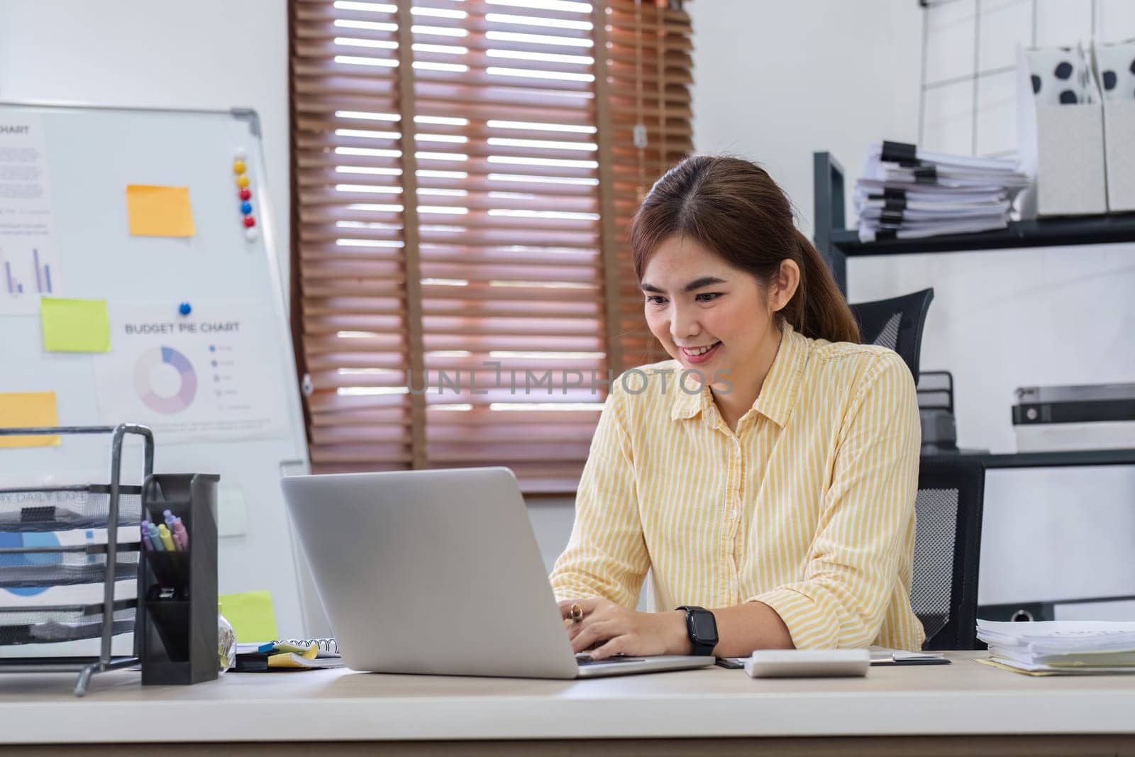 Businesswoman uses laptop to do finance, mathematics on wooden table in office and business background, tax, accounting, statistics and analytical research concept..