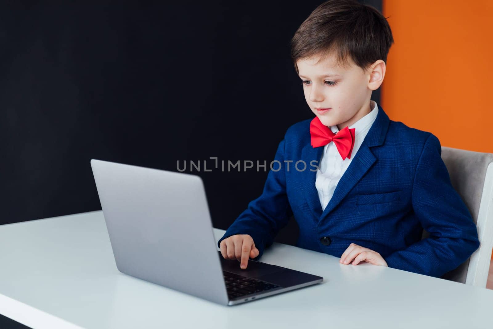 boy at the computer in the classroom learning online school IT programming by Simakov