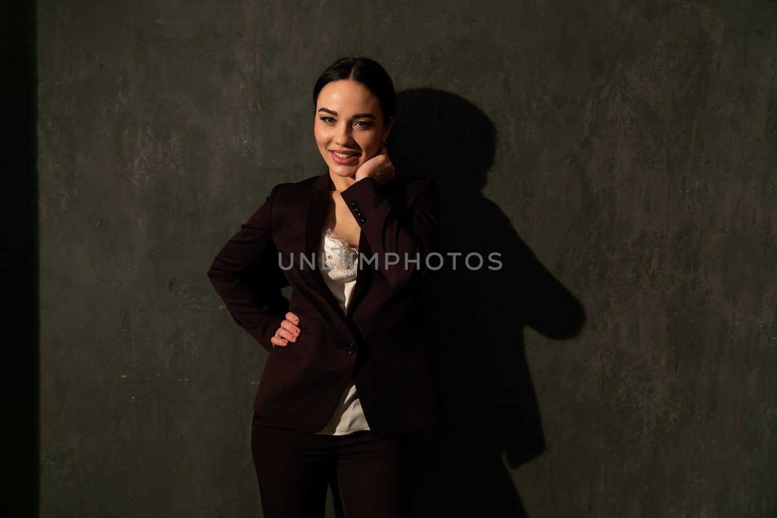beautiful woman in a dark business suit in the office laughs by Simakov