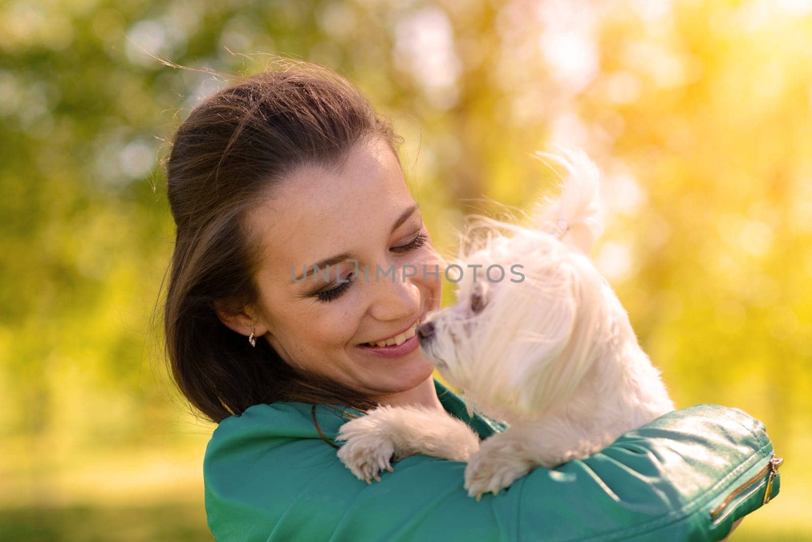 Young girl with her dog. Puppy white dog is running with it's owner. Conception about friendship, animal and freedom.