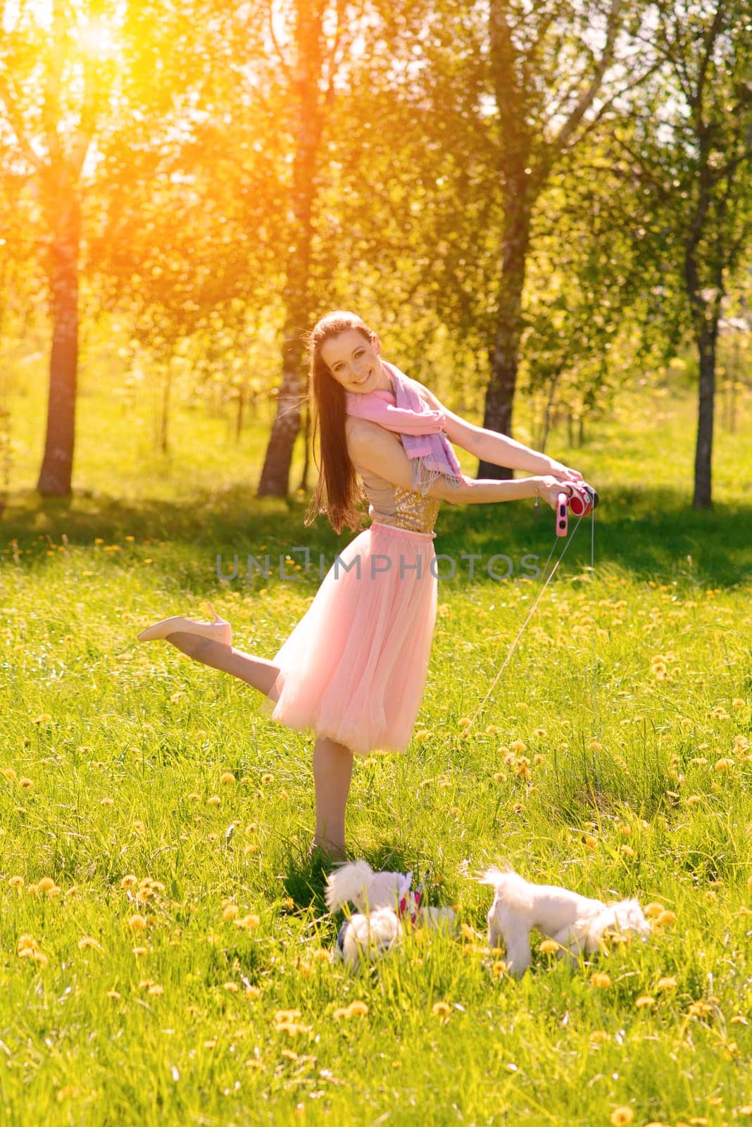 Young girl with her dog. Puppy white dog is running with it's owner. Conception about friendship, animal and freedom.