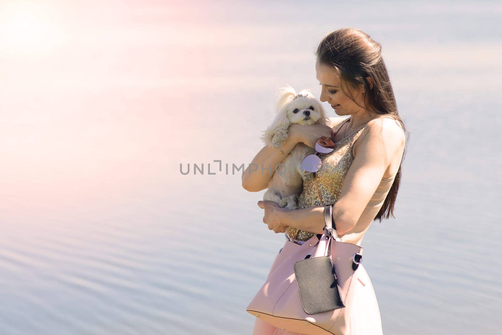 Young woman with her dog. Puppy white dog is running with it's owner. Concept about friendship and animal.