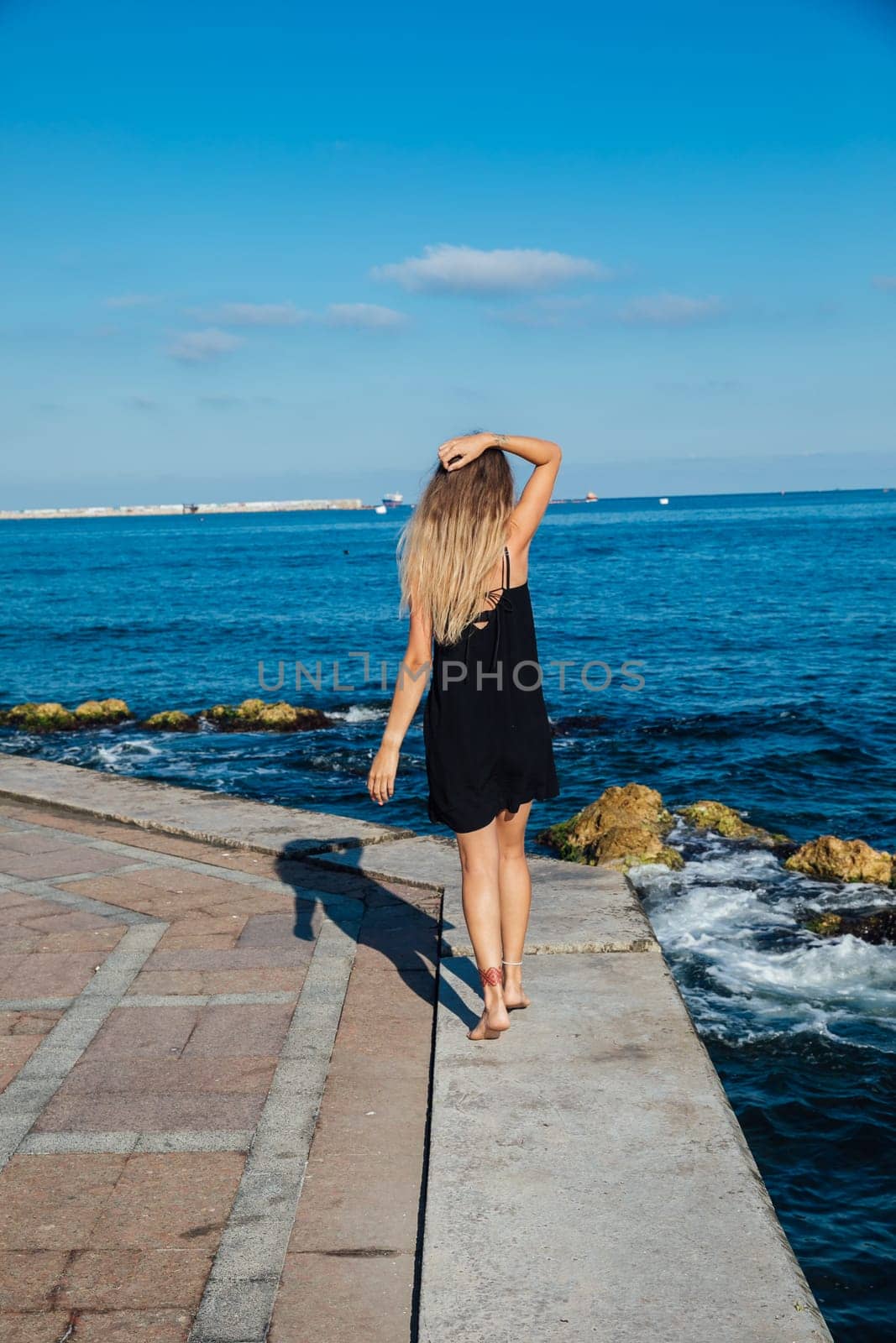woman walks along a pier near the sea walking the beach