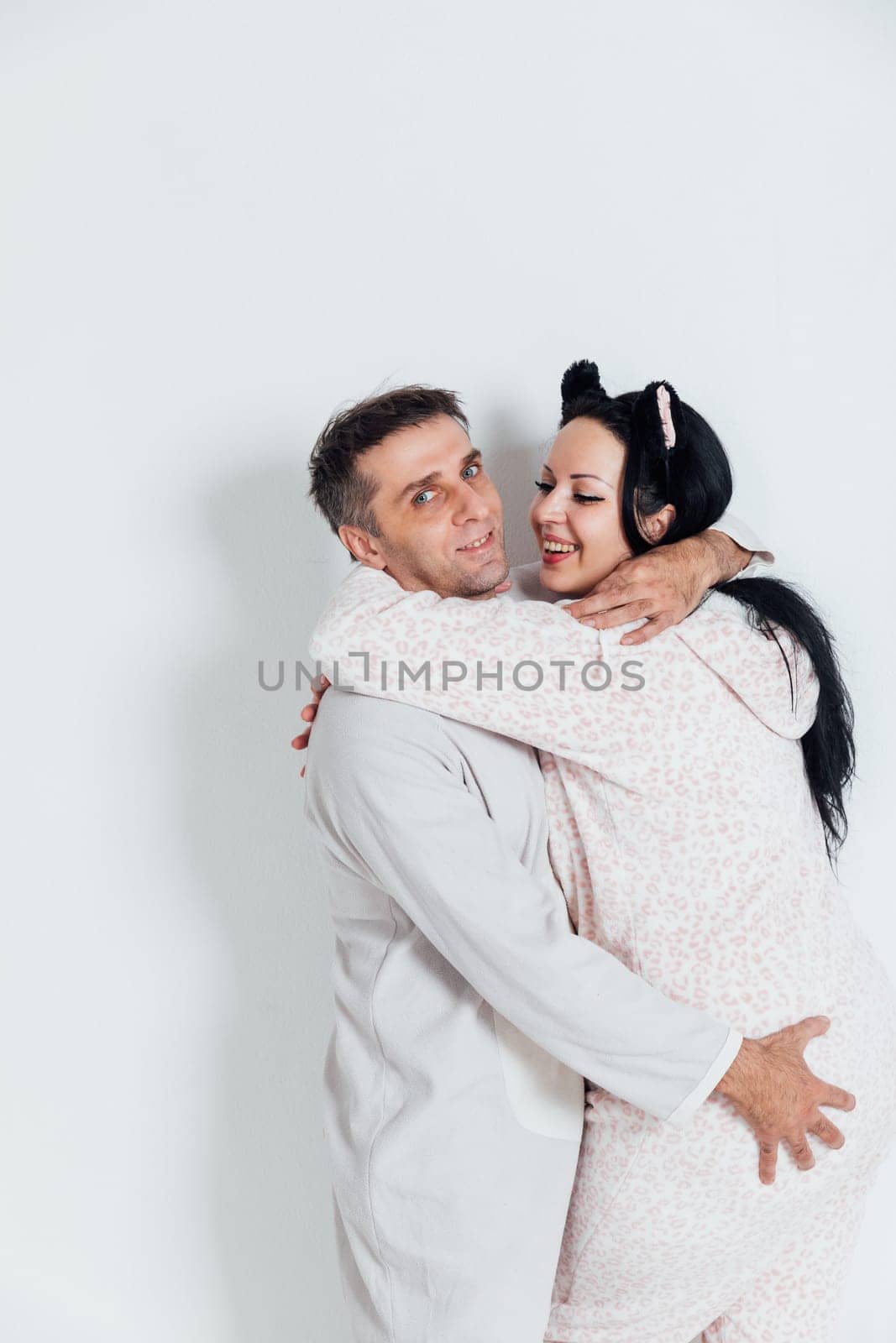 a husband and wife man and woman in love in pajamas in the morning in a bright room
