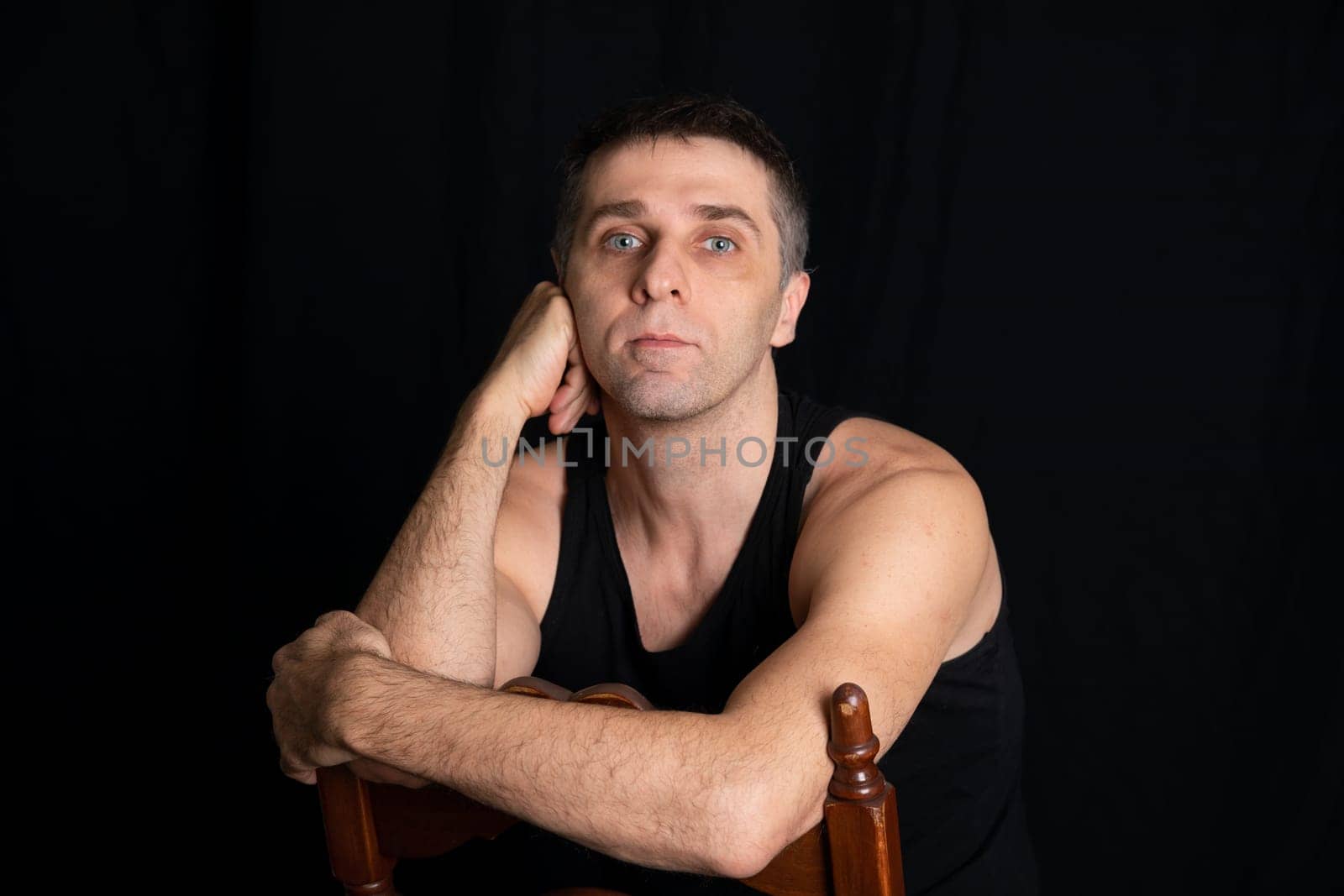 man in dark clothes sits in a dark room