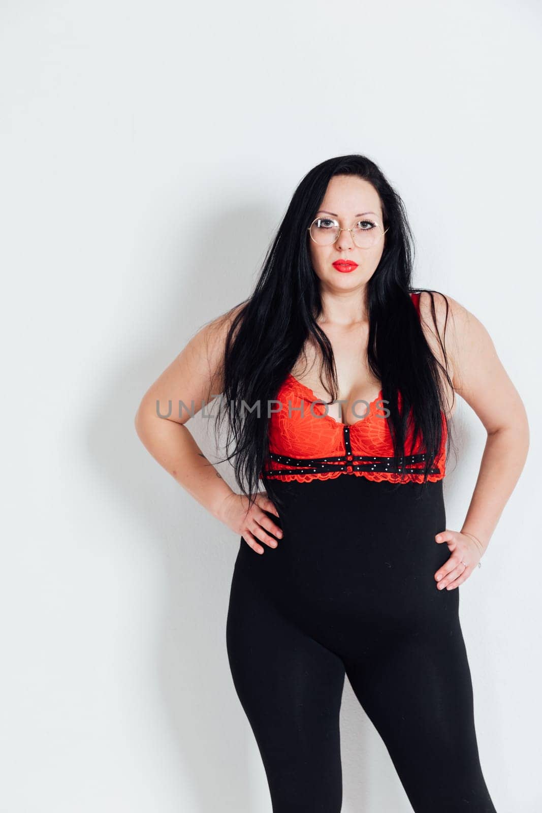 fat woman standing against a white wall in a room