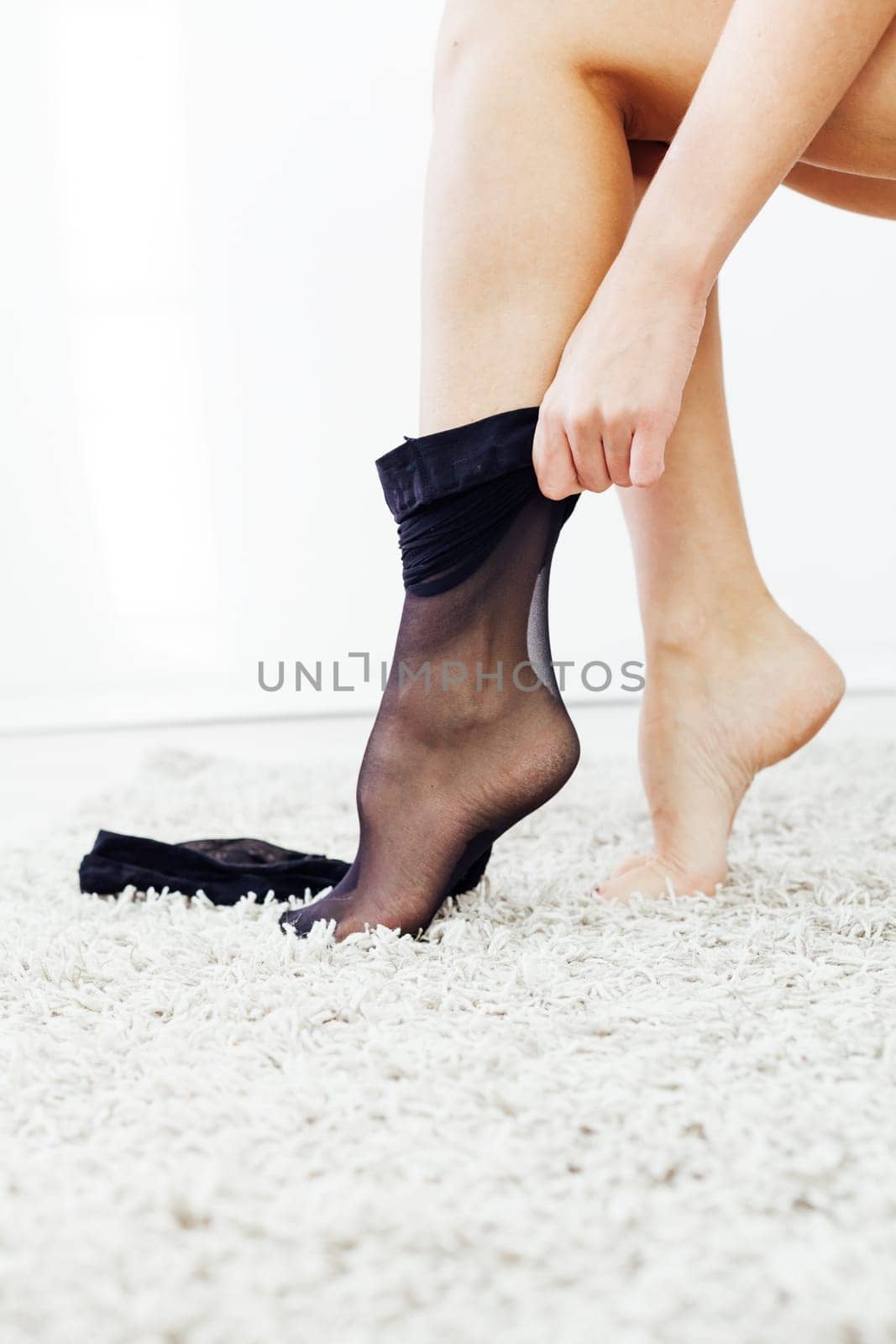 woman puts on her legs tights slender legs black tights