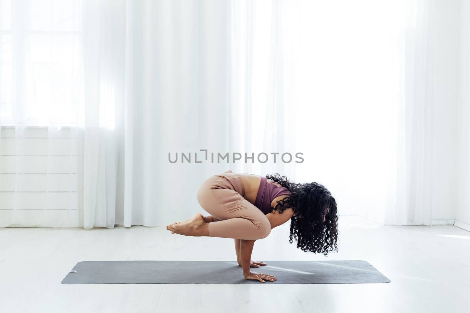 a woman doing yoga acrobat gymnast exercises for weight loss flexibility of the body