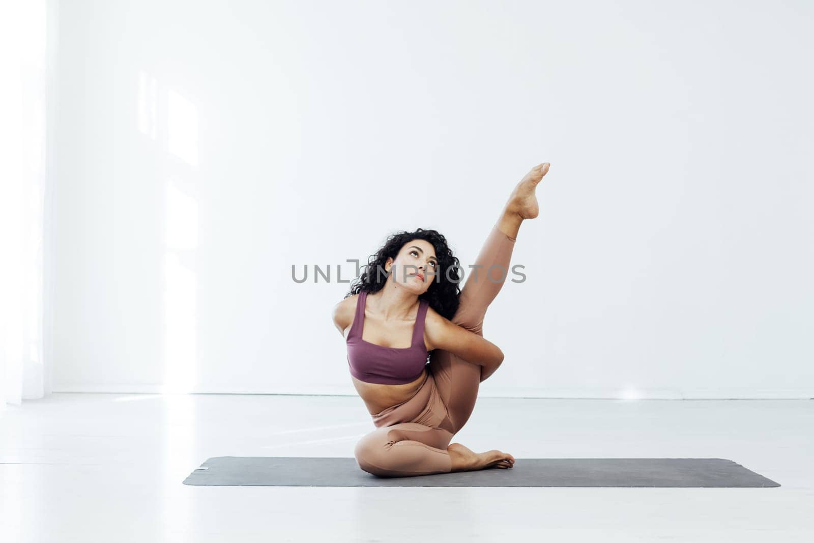 woman doing yoga acrobat gymnast exercises for weight loss flexibility of the body by Simakov