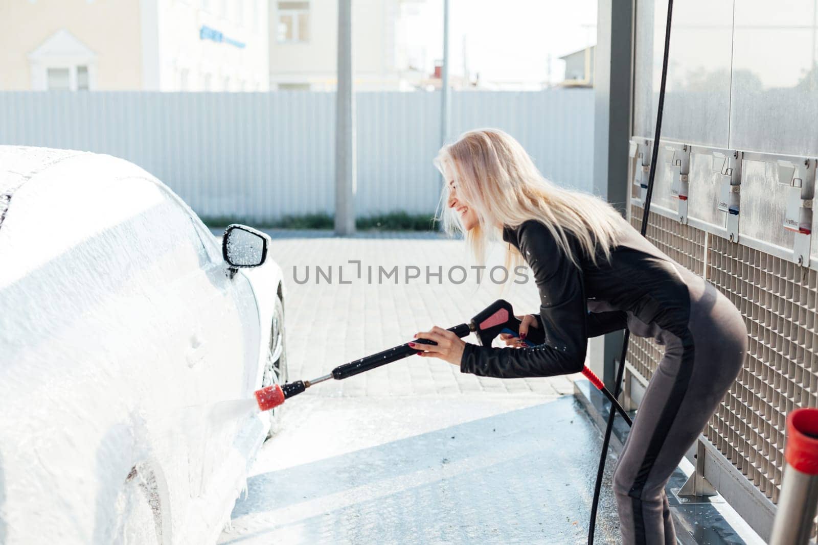 woman in a car washes a car with foam