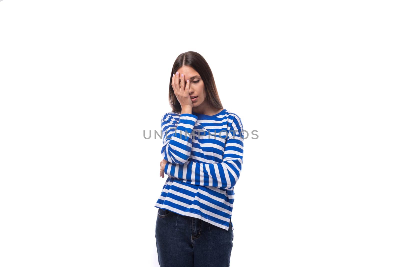 portrait of a young pretty caucasian woman with dark hair dressed in a blue striped sweatshirt on a white background. people lifestyle concept.