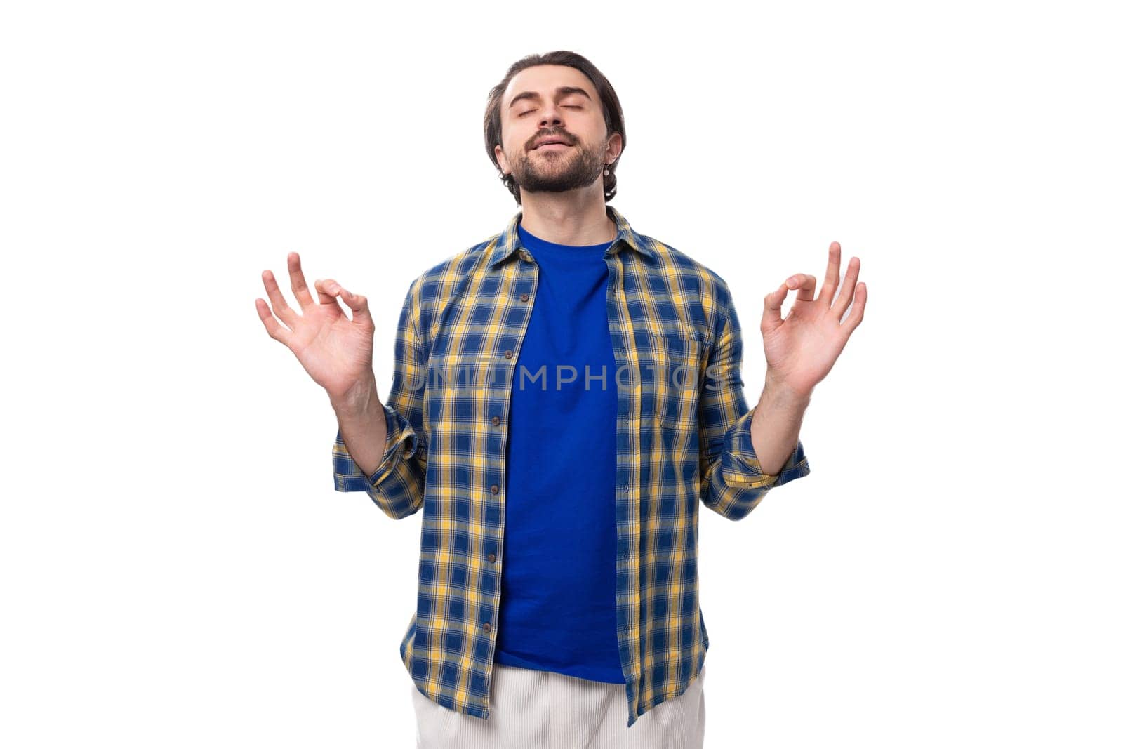 portrait of a pleasant calm young european brunette with a beard dressed stylishly in a shirt.