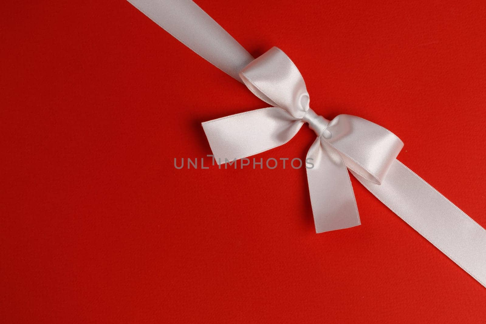 White gift bow on red by Yellowj