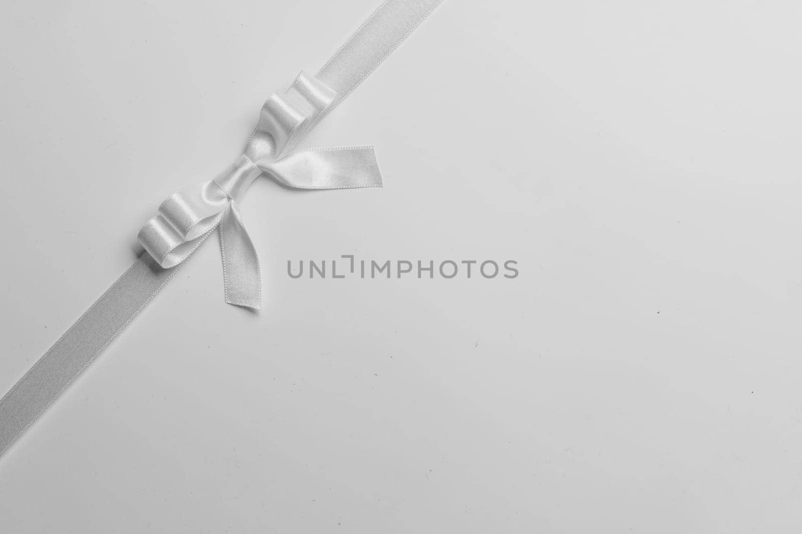 White ribbon bow on gray by Yellowj