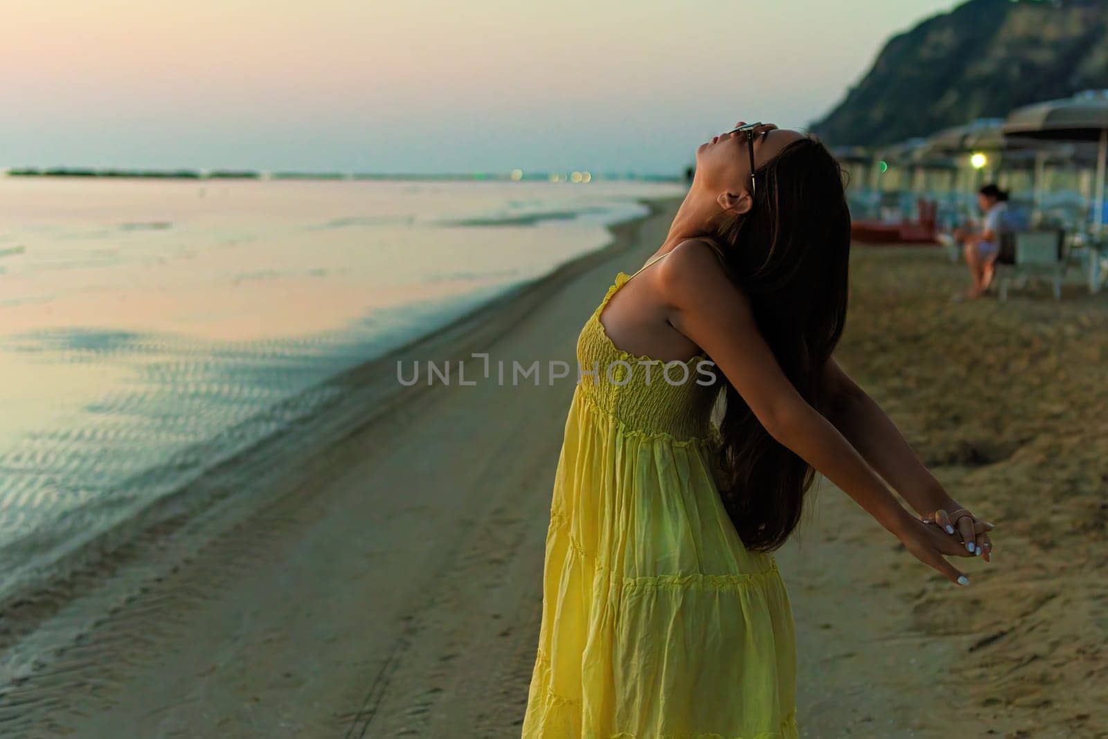 Young woman doing flexible yoga in summer day lifestyle relax and chill on the beach. by AliaksandrFilimonau