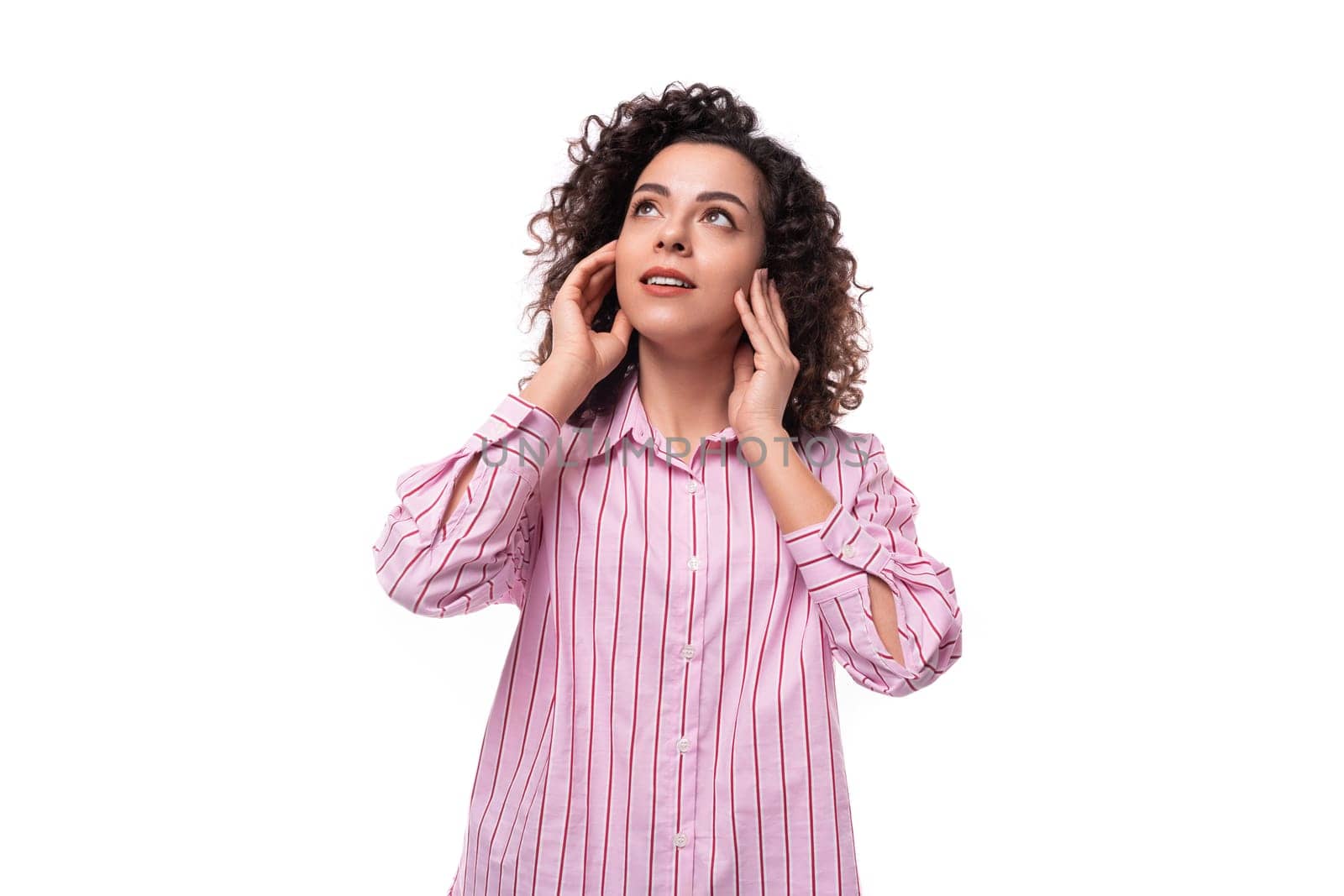 young caucasian leader woman with a curly haircut is dressed in a pink shirt on a white background.