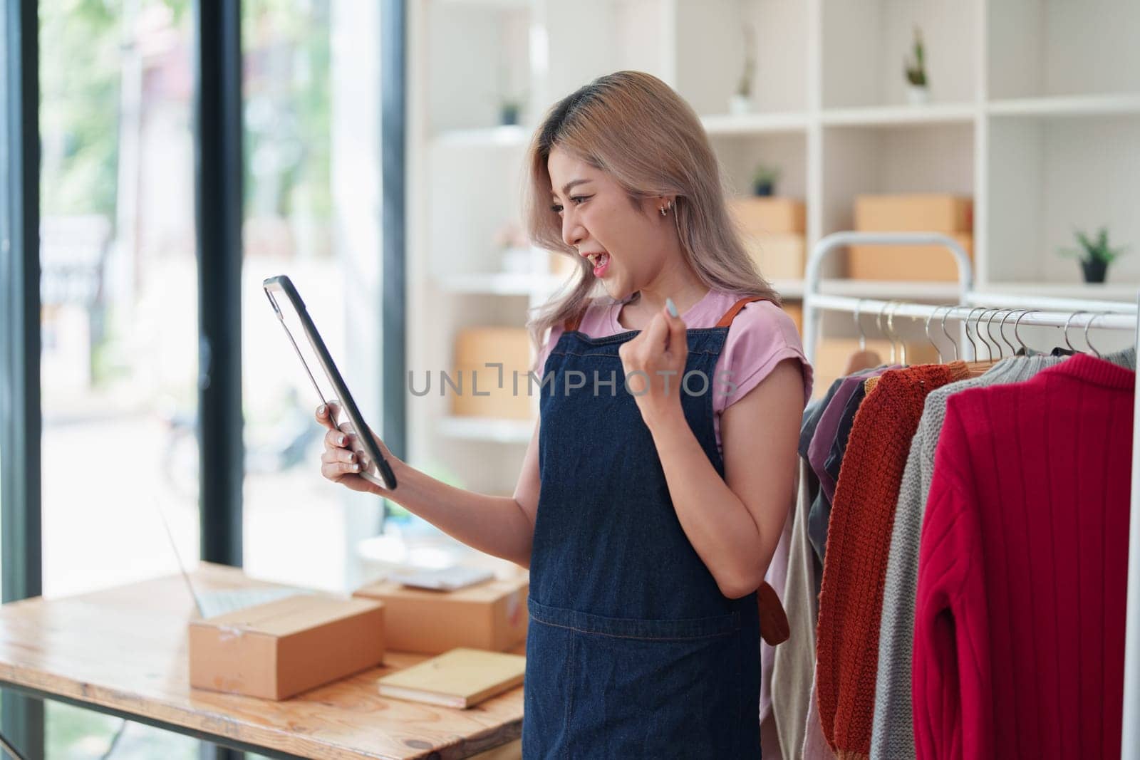 Portrait Of Asian Female Owner Of Fashion Store Clothing Store successful happy smile at small business, sme or ecommerce concepts by Manastrong