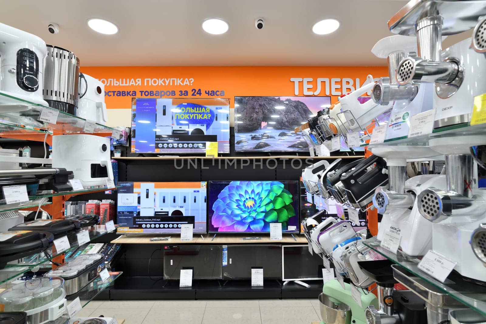 Moscow, Russia - Nov 11. 2023. TV and electric meat grinder in DNS network store selling household appliances in Zelenograd by olgavolodina