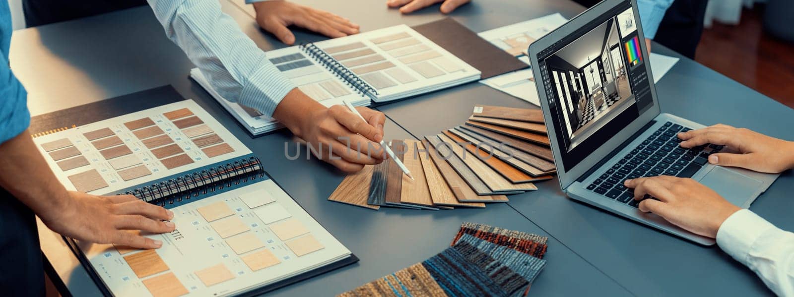 Group of interior architect designer team at table choosing various mood board samples with architecture software on laptop screen. Modern renovation and interior material selection concept. Insight