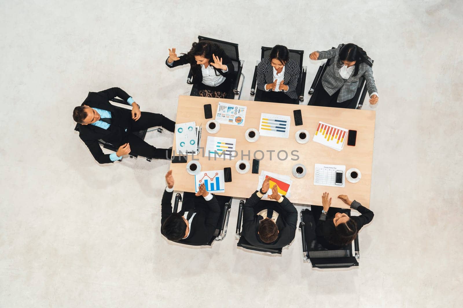 Successful business people celebrate together with joy at office table shot from top view . Young businessman and businesswoman workers express cheerful victory showing success by teamwork . Jivy