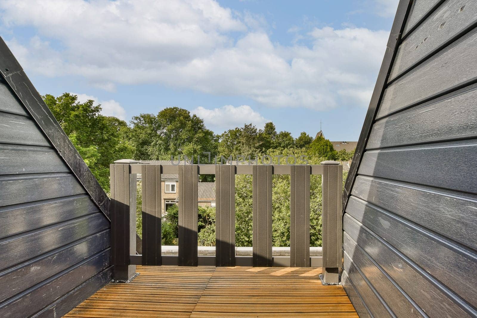 a deck with wooden boards and a view of trees by casamedia