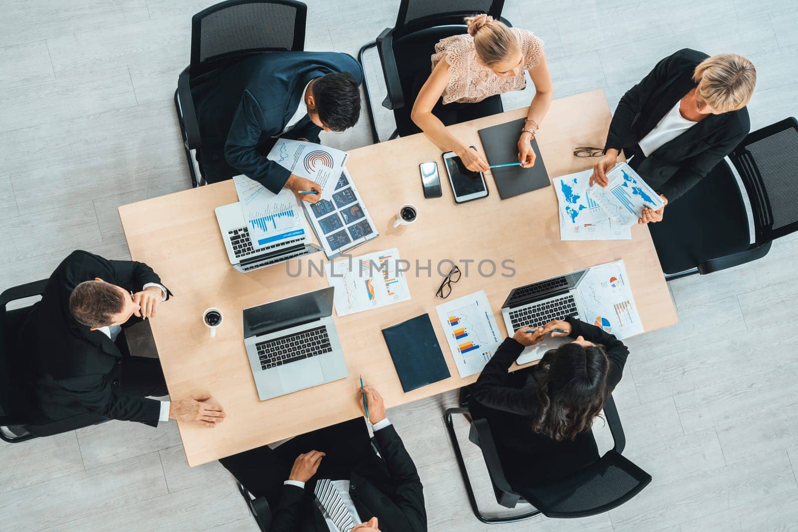 Business people group meeting shot from top view in office . Profession businesswomen, businessmen and office workers working in team conference with project planning document on meeting table . Jivy