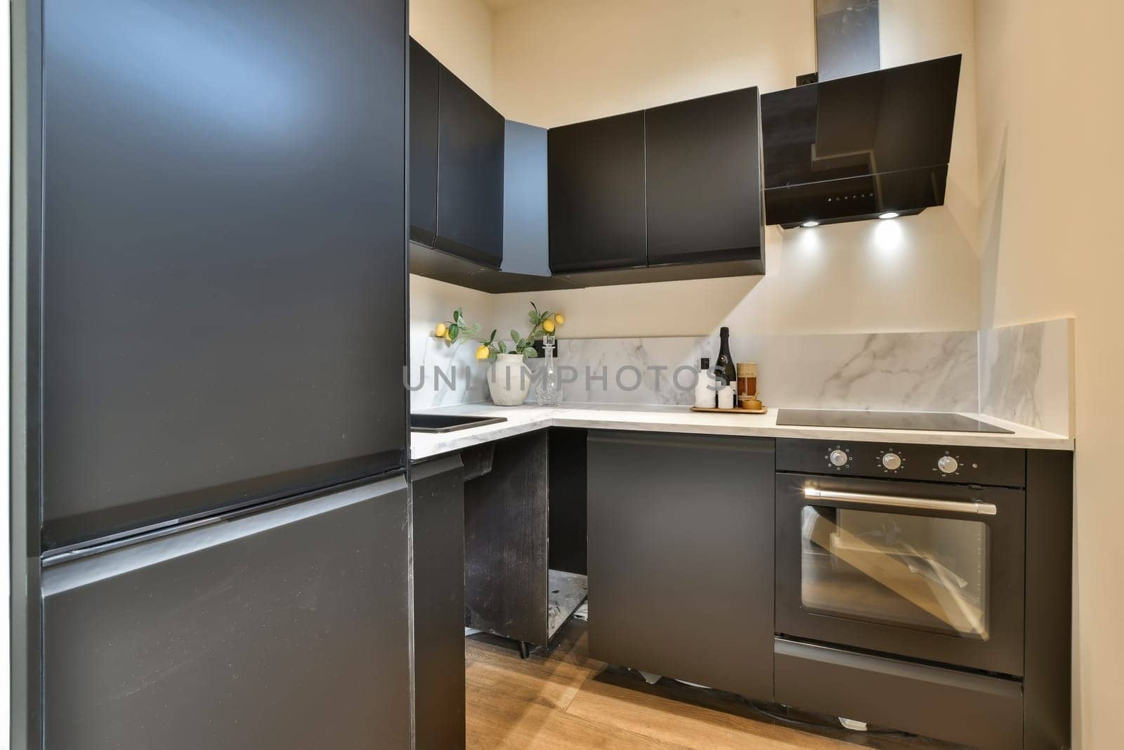 a kitchen with black cabinets and a stove and oven by casamedia