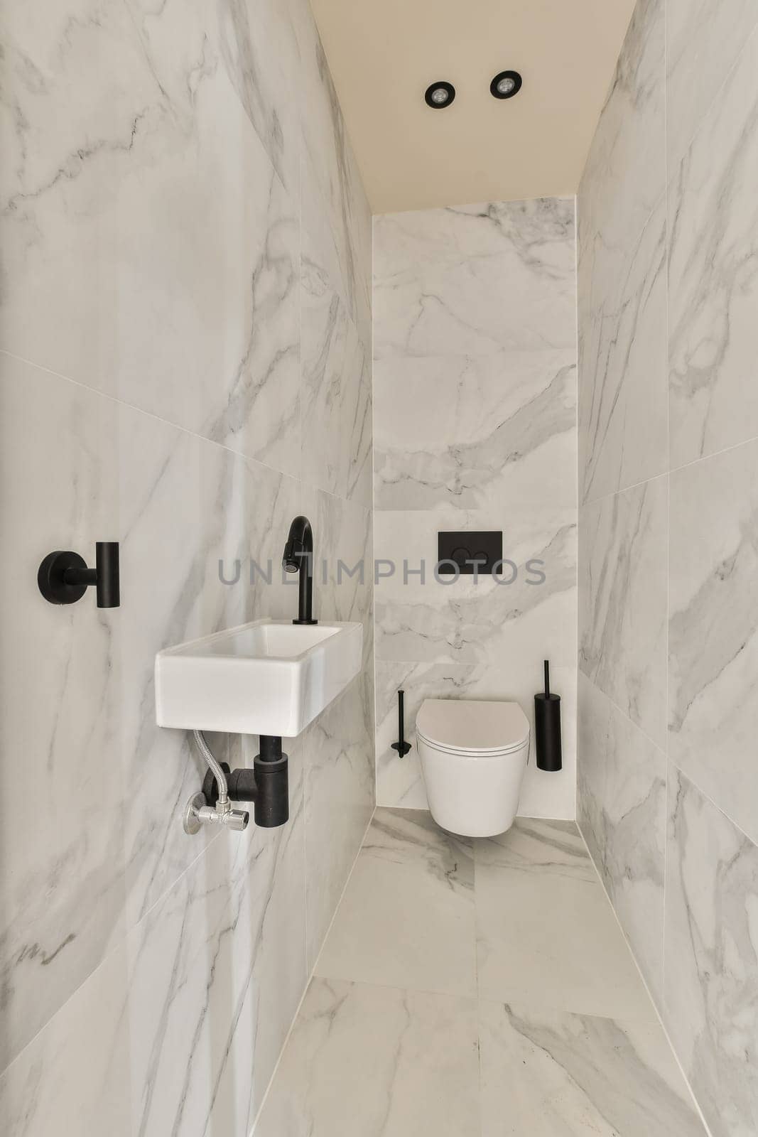 a bathroom with marble walls and a toilet and sink by casamedia