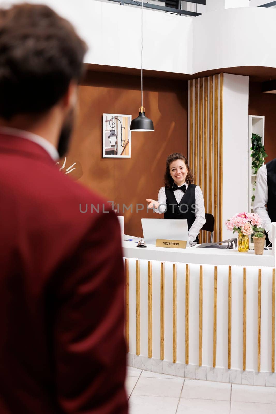 Employee welcoming businessman in lobby by DCStudio