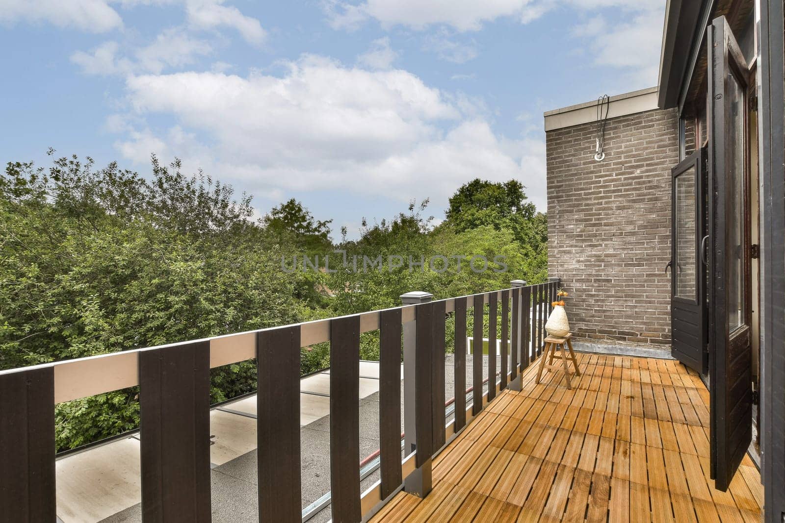 a balcony with a wooden deck and a brick building by casamedia